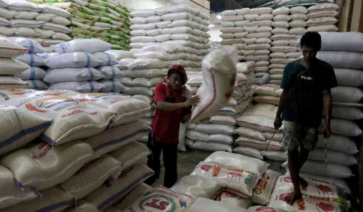 Pekerja tengah menata beras karungan di Pasar Induk Beras Cipinang, Jakarta.