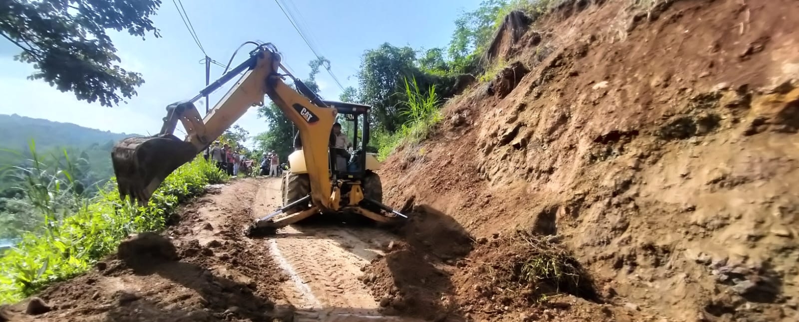 Sebuah alat berat melakukan pembersihan tanah longsor yang terjadi di Garut
