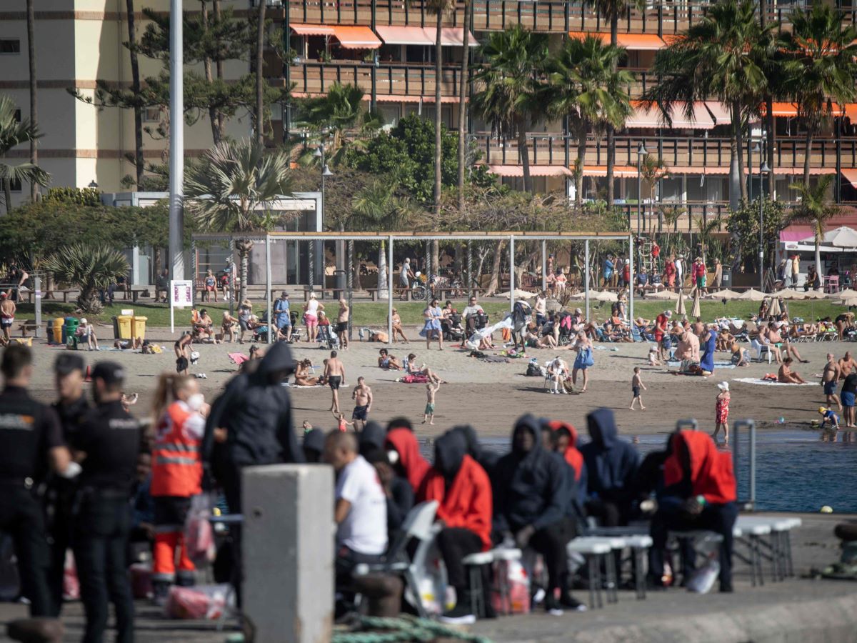 Wisatawan di pantai menikmati hari yang cerah di Spanyol.