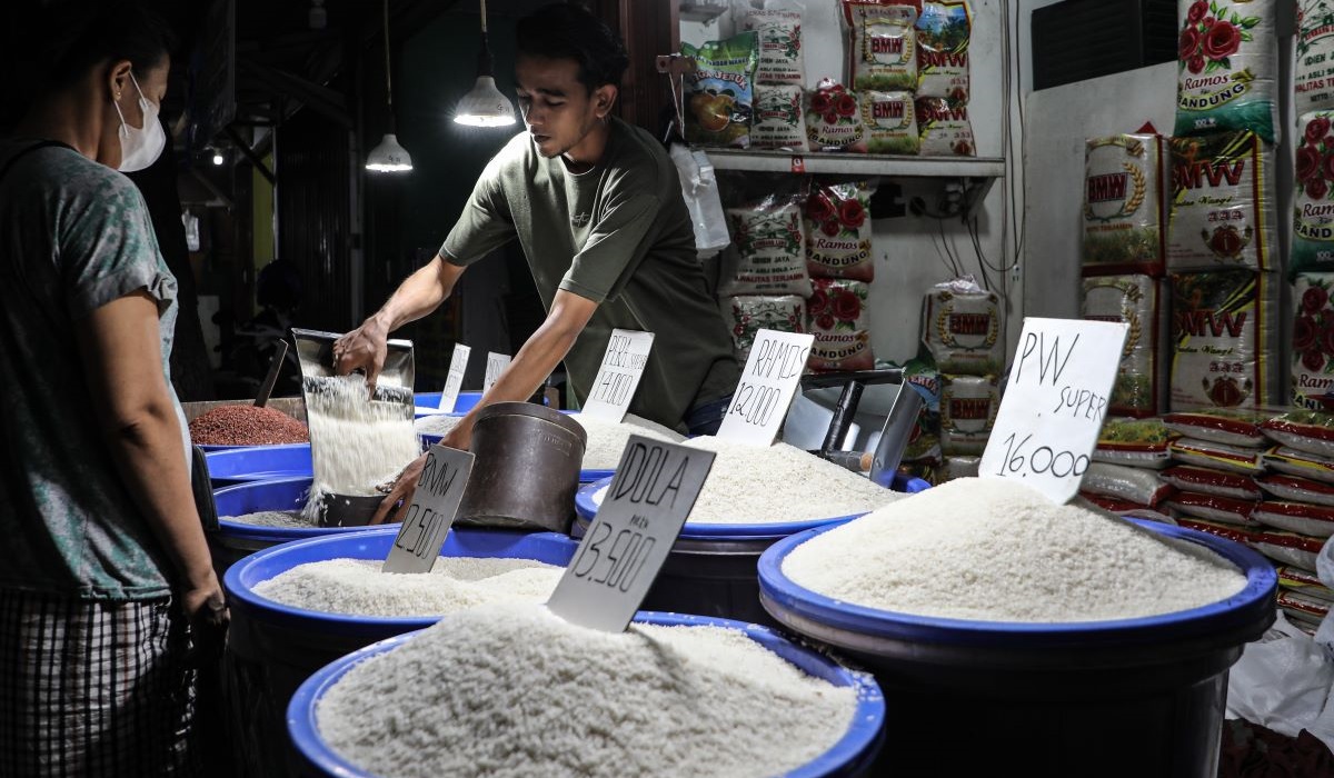 Pedagang melayani pembeli di kios penjualan beras medium dan premium kawasan Petukangan Utara, Jakarta Selatan, Senin (26/2/2024) malam.