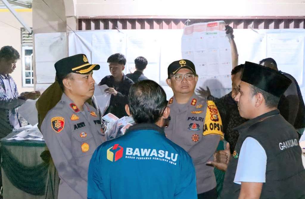 Kapolres Siak AKBP Asep Sujarwadi (tengah) memimpin patroli malam saat meninjau proses penghitungan suara TPS, di Siak, Riau.