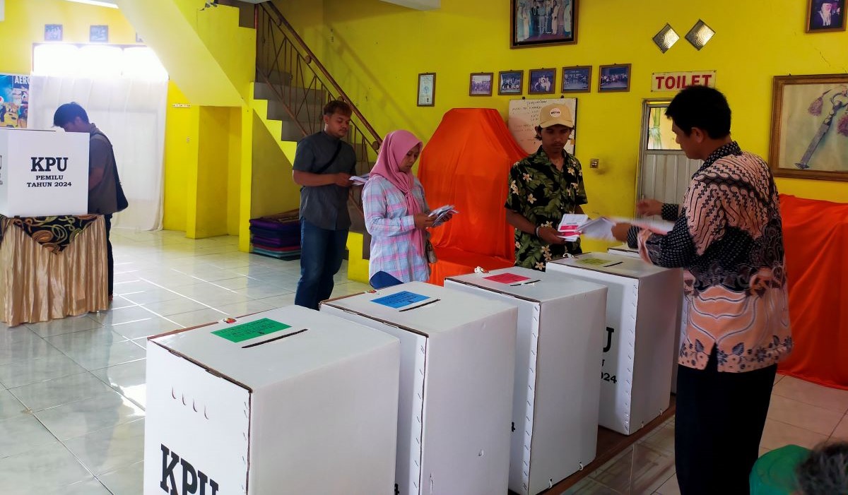 Petugas KPPS di TPS 37, RW 13, Kelurahan Cikalang, Kecamatan Tawang,Kota Tasikmalaya, membantu pemilih 