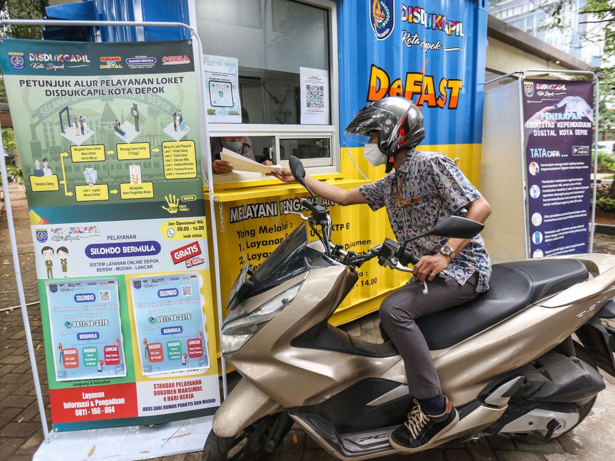 Warga mengambil dokumen kependudukan melalui layanan tanpa turun De Fast di halaman Kantor Pemkot Depok, Depok, Jawa Barat.
