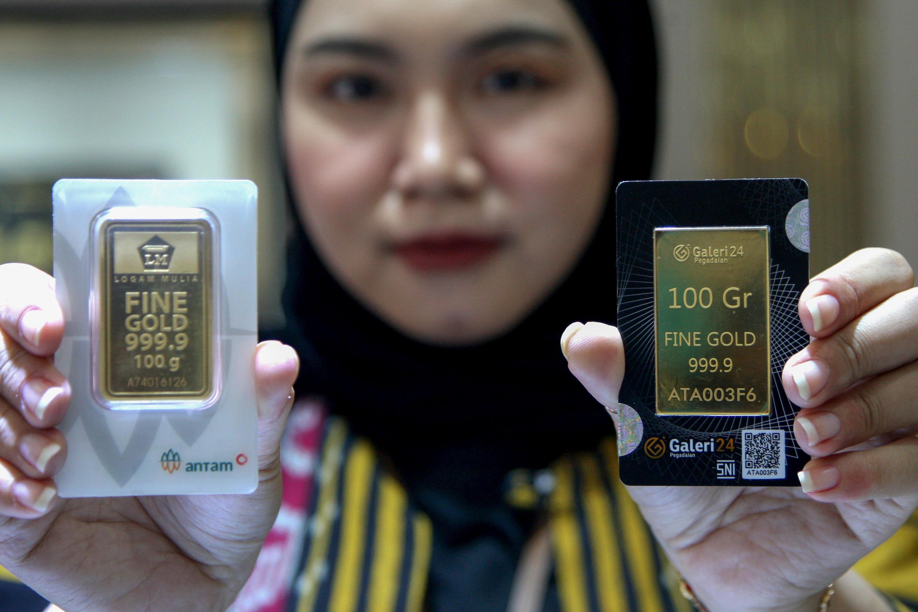 Petugas memperlihatkan emas 100 gram keluaran Antam di Pegadaian Jakarta, Selasa (6/2).