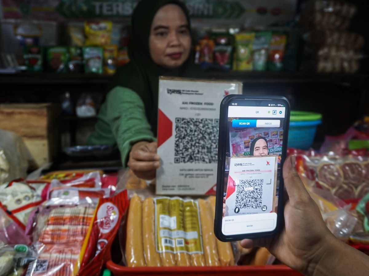 Pembeli melakukan pembayaran secara digital menggunakan QRIS di Pasar Tradisional Pasar Minggu, Jakarta.