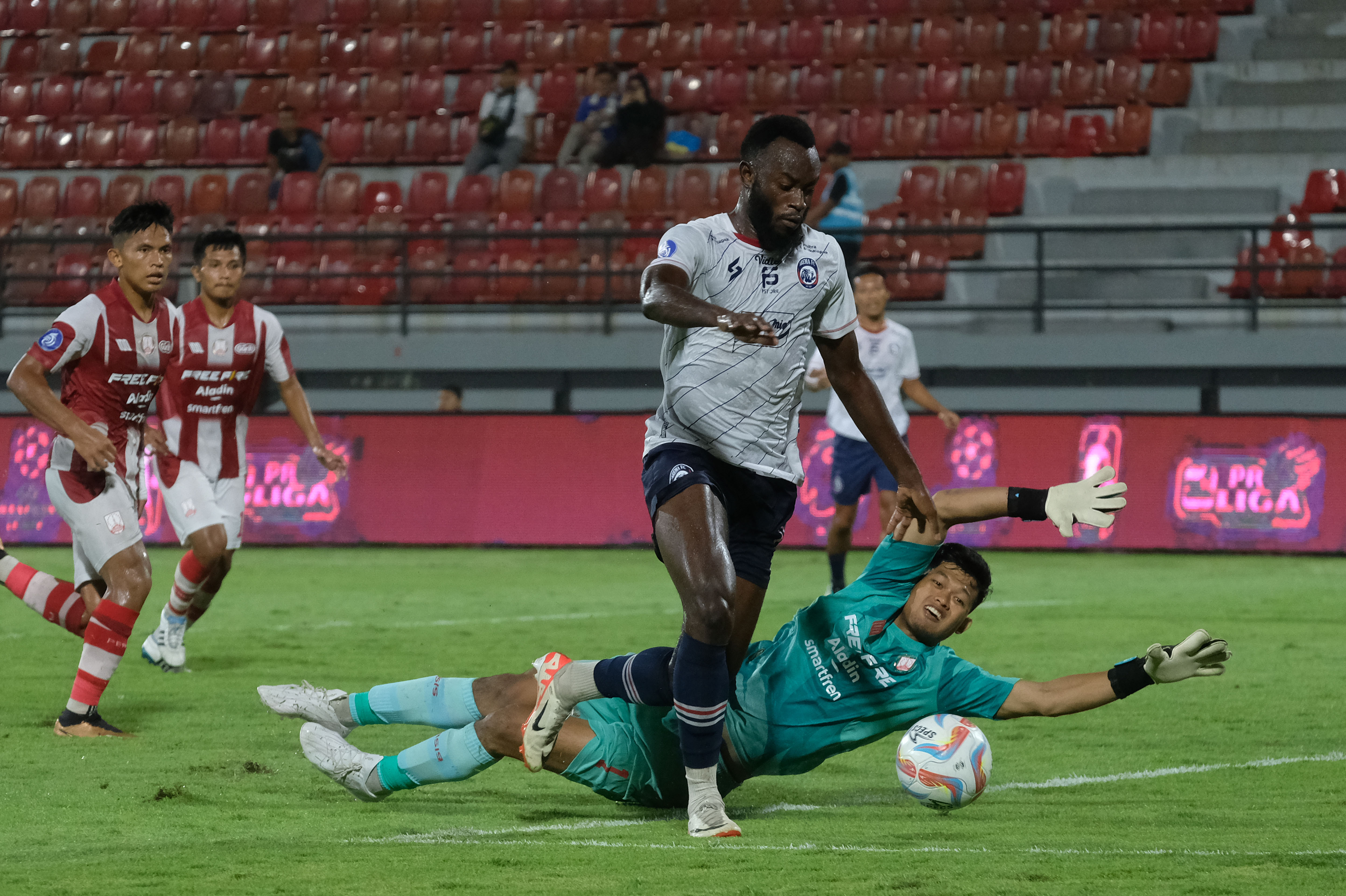 Pesepak bola Arema FC Charles Lokolingoy (kedua kanan) berusaha melewati penjaga gawang Persis Solo Muhamad Riyandi (kanan)