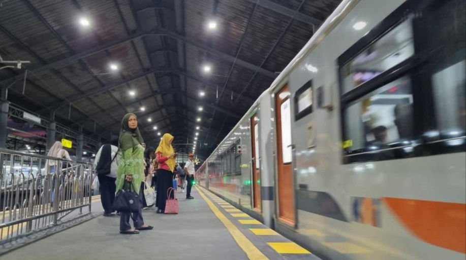 Para penumpang sedang menunggu kereta di sebuah stasiun.
