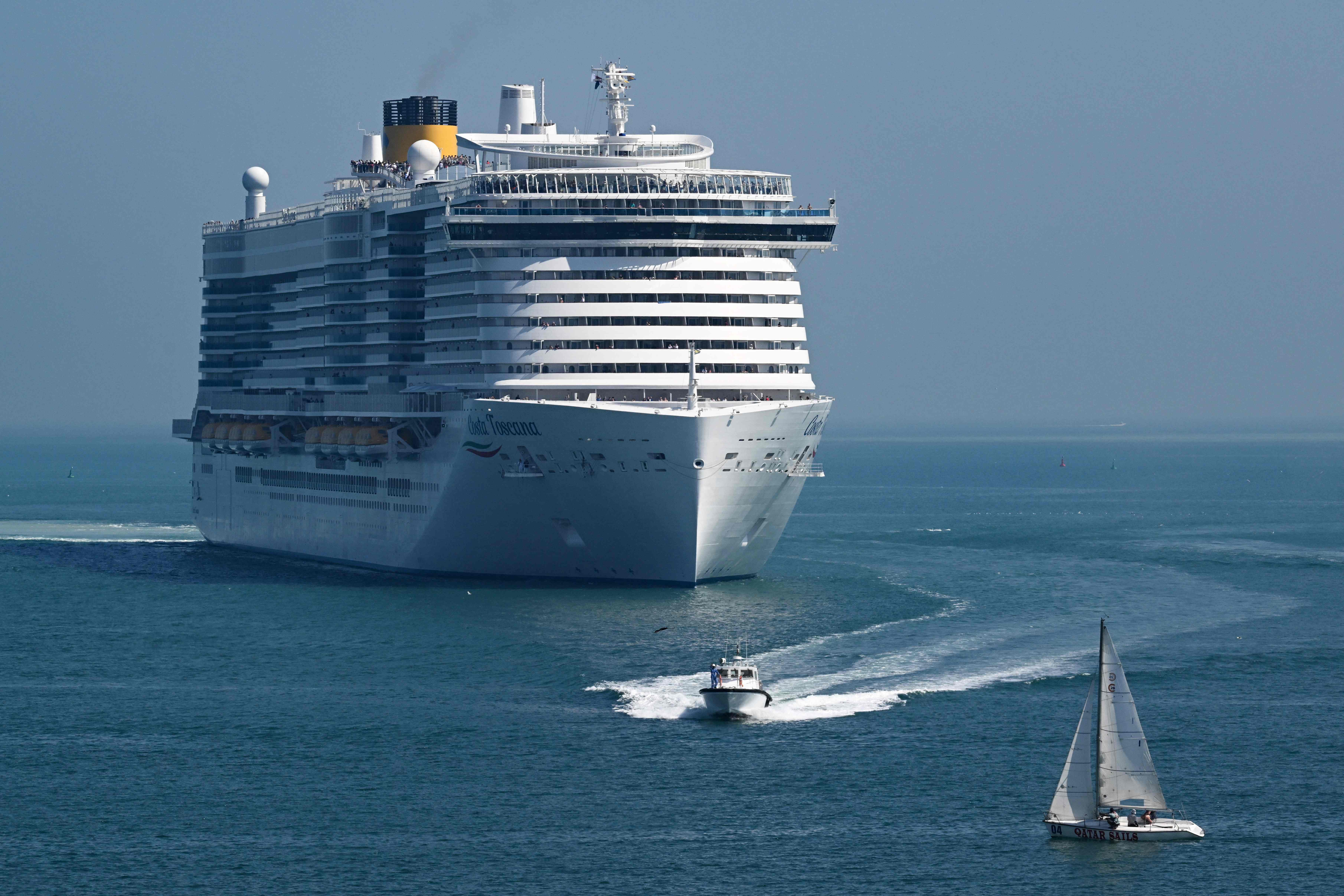 Sebuah perahu layar lewat di depan kapal pesiar di Pelabuhan lama Doha, Qatar, pada 13 Februari 2024. 