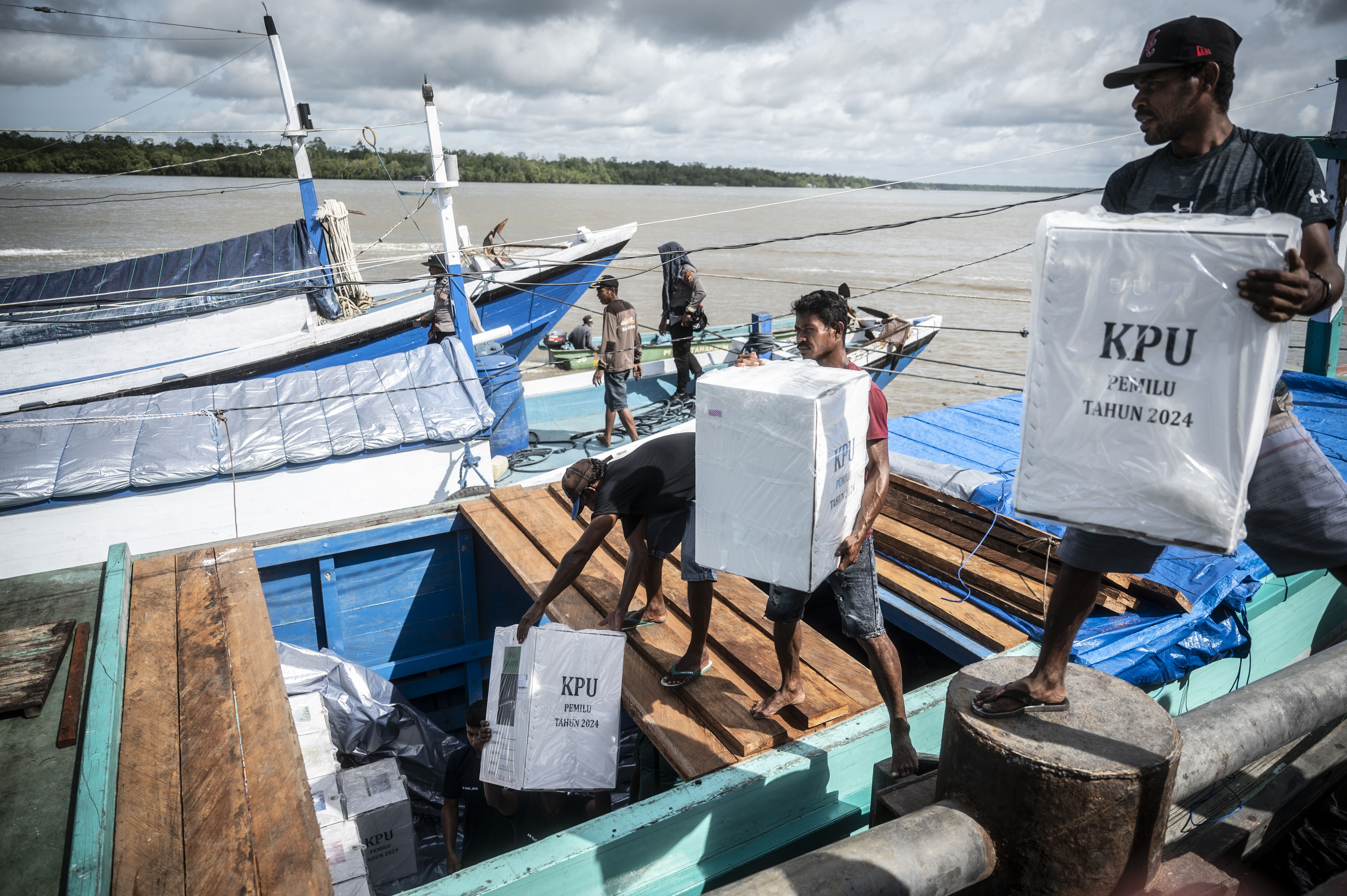 Pekerja memindahkan logistik Pemilu 2024 ke kapal motor Irma Jaya di dermaga feri Distrik Agats, Kabupaten Asmat, Papua Selatan.