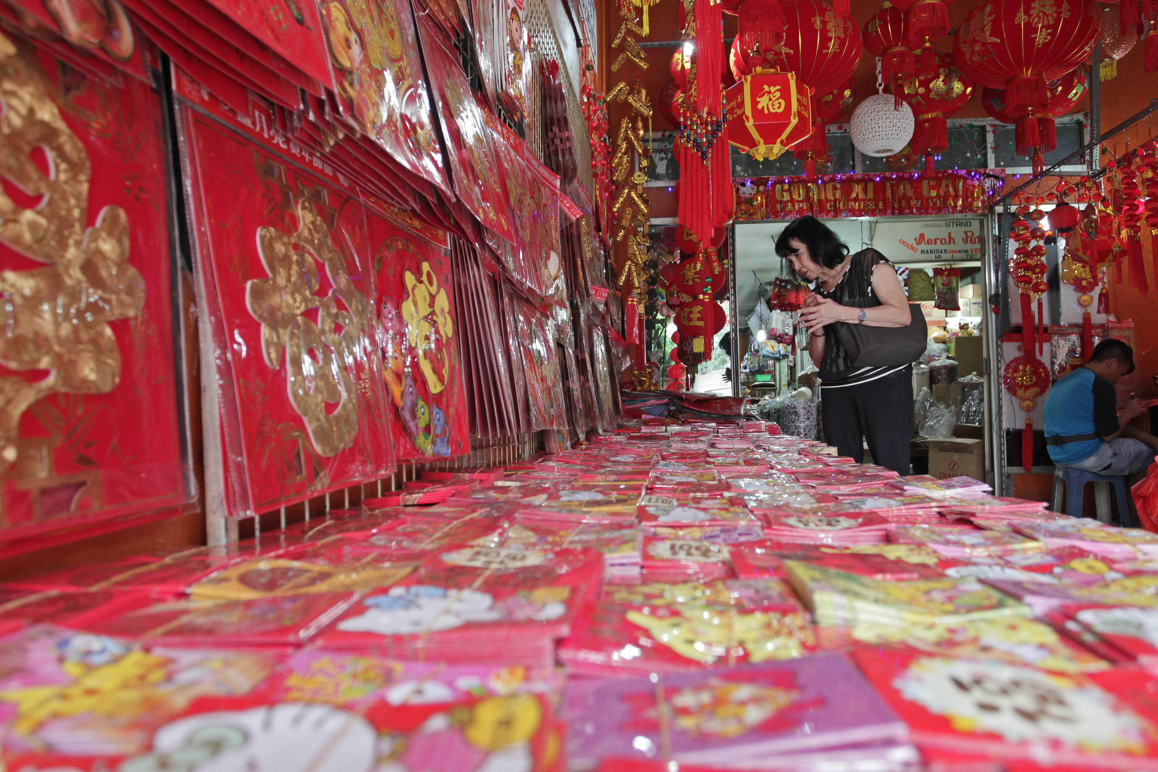 Pembeli memilih amplop angpao yang dijual di toko pernak-pernik imlek