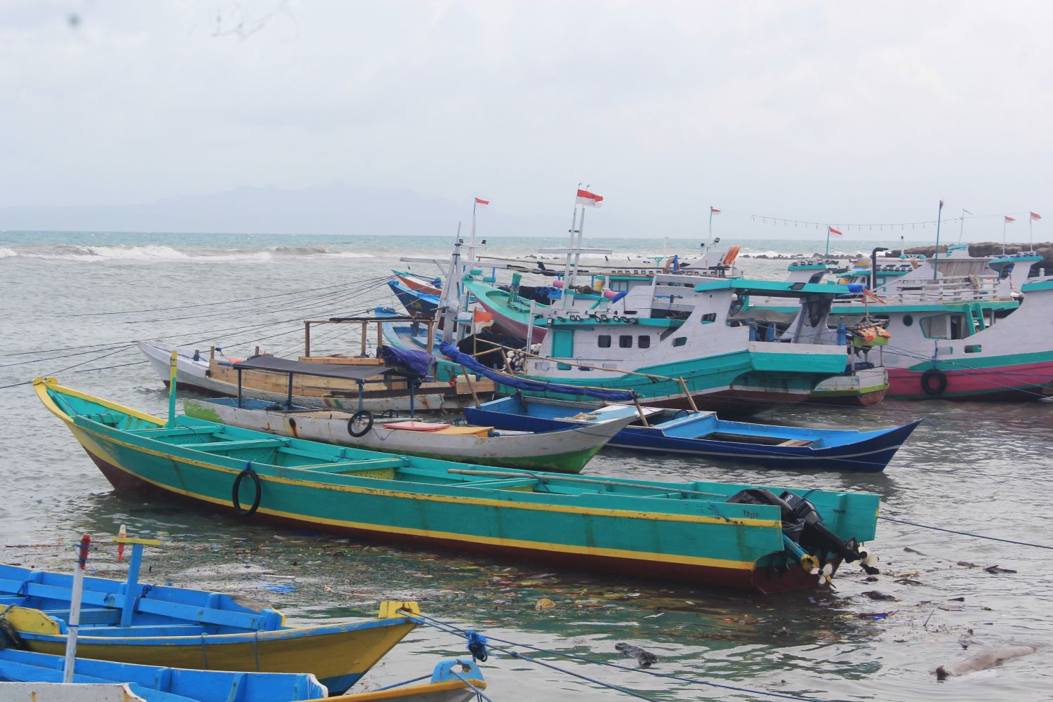 Akibat cuaca buruk, perahu nelayan hanya bisa bersandar di pinggir pantai Kota Kupang, Nusa Tenggara Timur (NTT), Minggu (1/1/2023). 