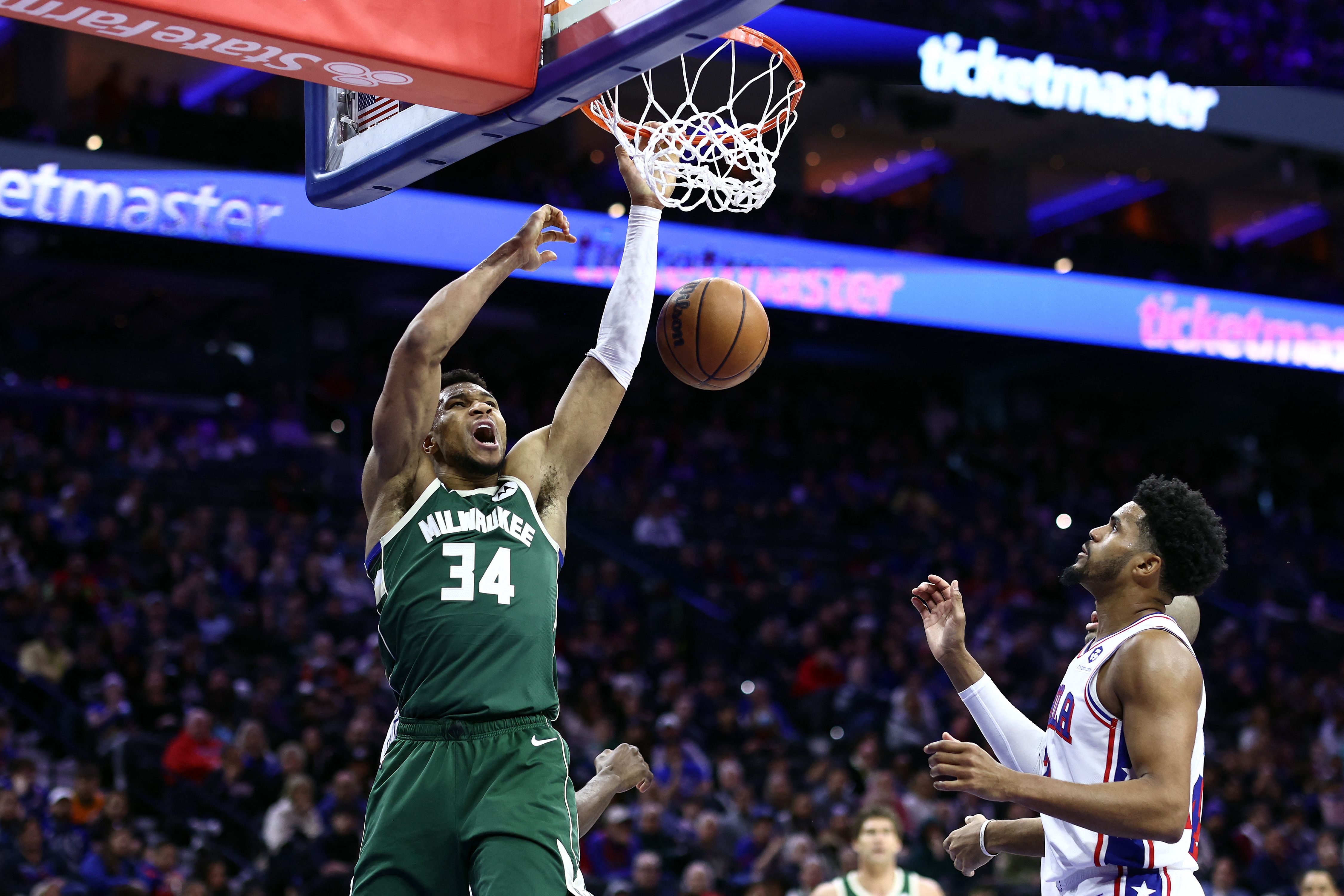 Pebasket Milwaukee Bucks Giannis Antetokounmpo (kiri) melakukan dunk saat timnya berjumpa dengan Philadelphia 76ers, Senin (26/2) WIB.