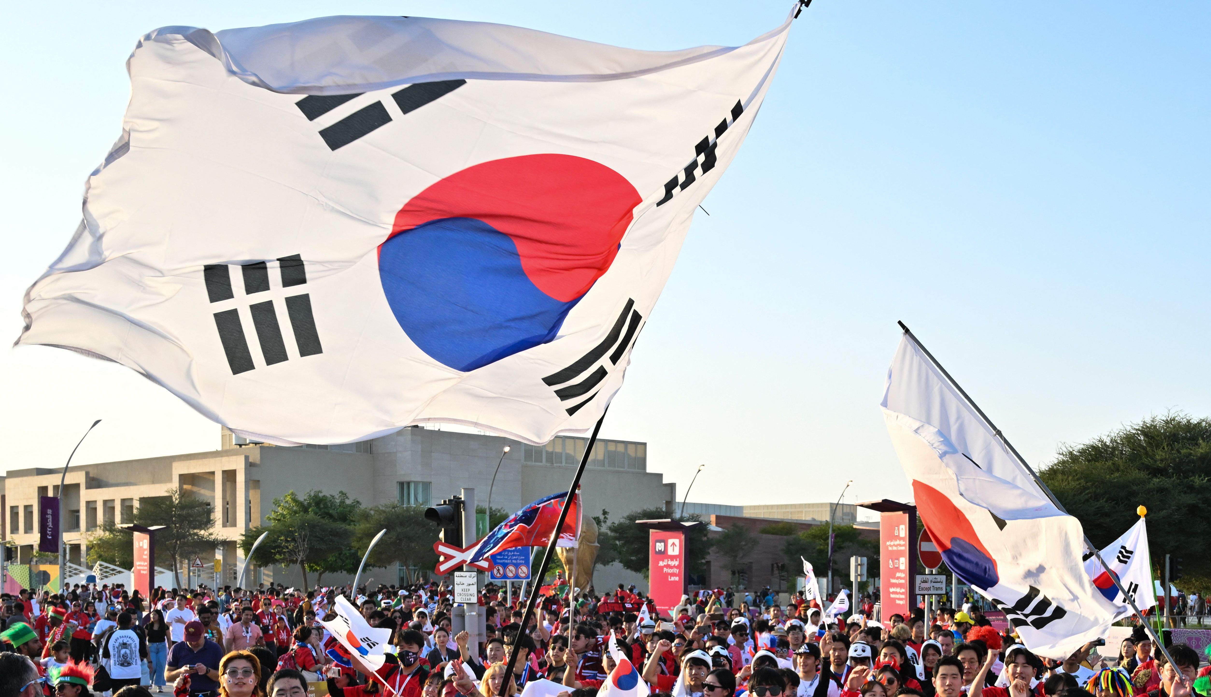 Warga Korea Selatan mengibarkan bendera nasional mereka di Qatar, Jumat (2/12/2022).