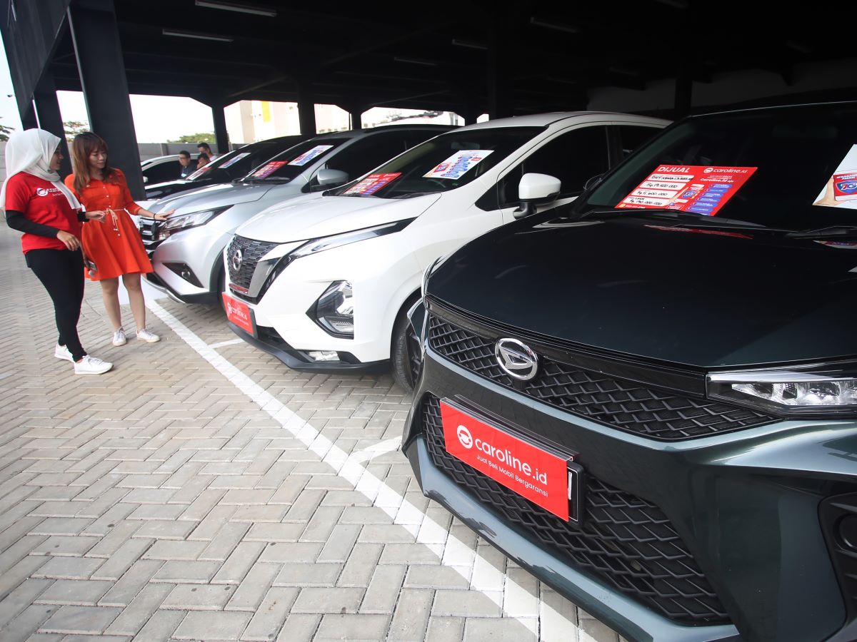 Calon pembeli didampingi tenaga penjual melihat mobil bekas yang dijual di showroom mobil bekas di Gading Serpong, Tangerang, Banten.