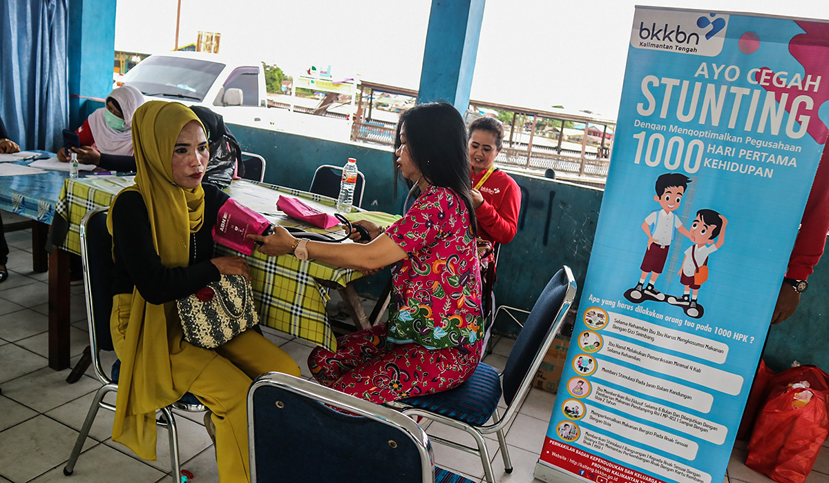 Petugas kesehatan memeriksa tekanan darah warga dalam program penurunan angka stunting dan mewujudkan keluarga kecil yang sejahtera.