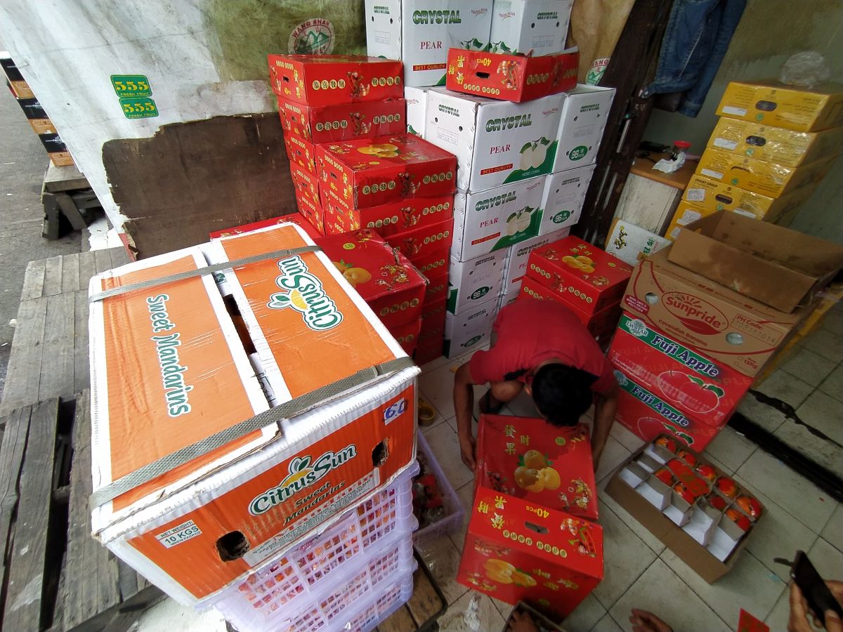 Pedagang merapikan jeruk impor di Pasar Induk Tanah Tinggi, Tangerang, Banten.