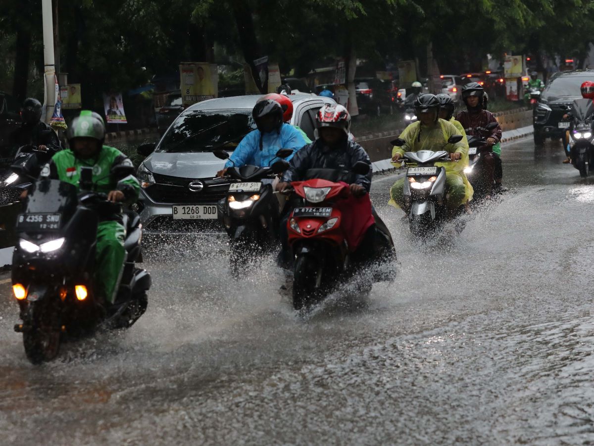 Pengendara sepeda motor melewati genangn air saat hujan deras di kawasan Alteri Pondok Indah Jakarta, Senin (5/2/2024).