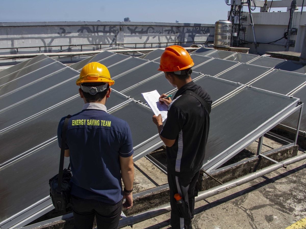 Petugas melakukan perawatan terhadap panel surya di atap gedung Hotel Claro, Makassar, Sulawesi Selatan, Rabu (2/8/2023).