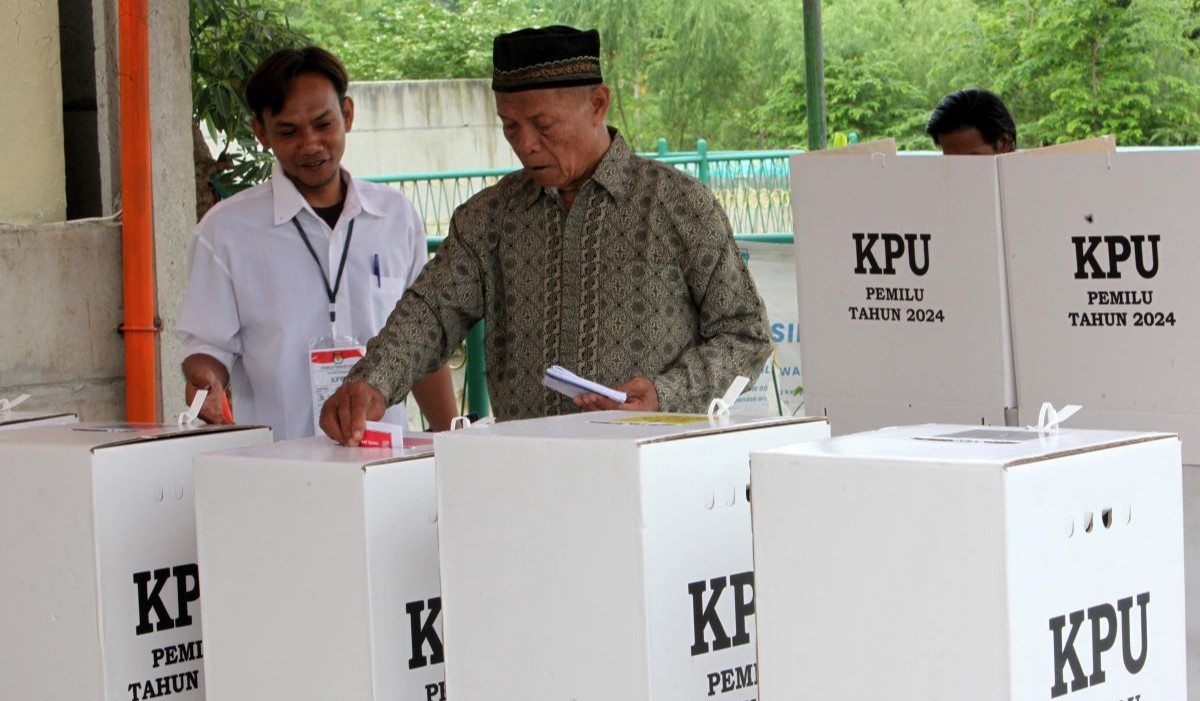Ilustrasi: Warga dibantu anggota Kelompok Penyelenggara Pemungutan Suara (KPPS) memberikan hak suaranya