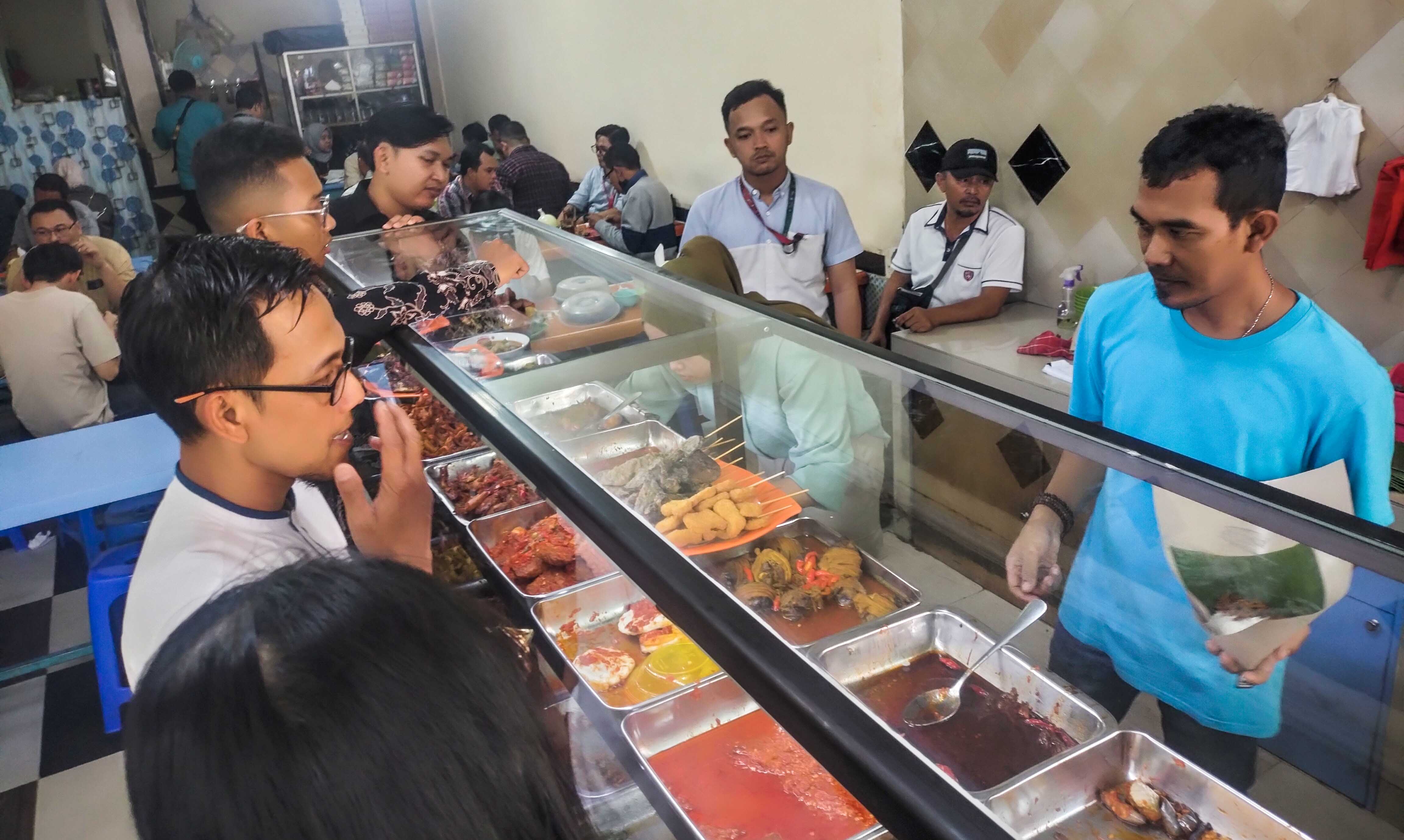 Pedagang kuliner tengah melayani pembeli