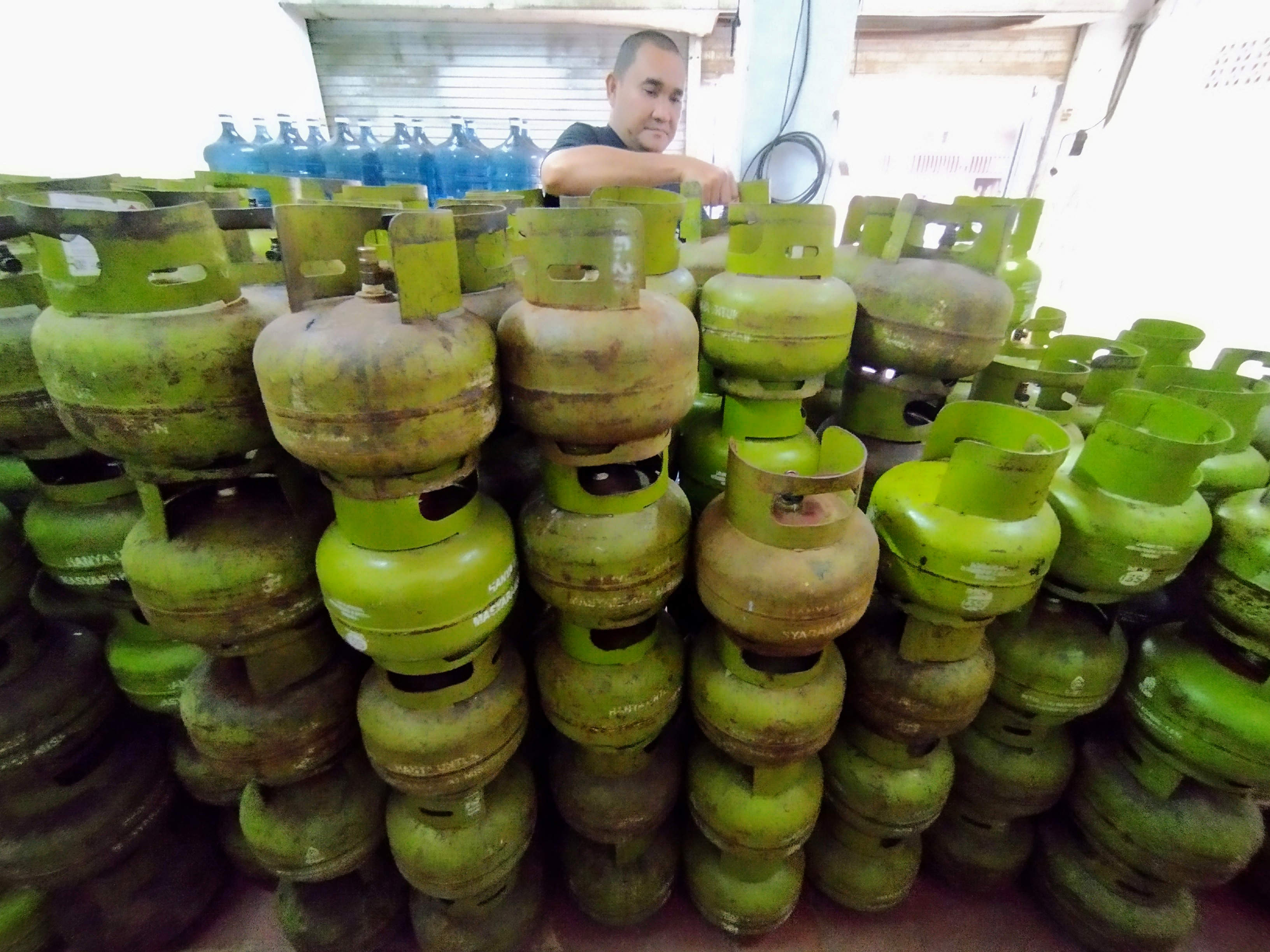 Penjual menata tabung gas elpiji (LPG) 3kg di tokonya.