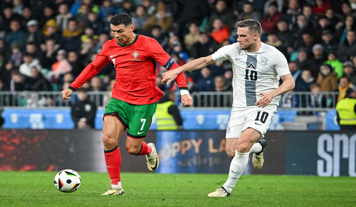 Penyerang Portugal Cristiano Ronaldo berusaha melewati adangan pemain Slovenia di laga persahabatan.
