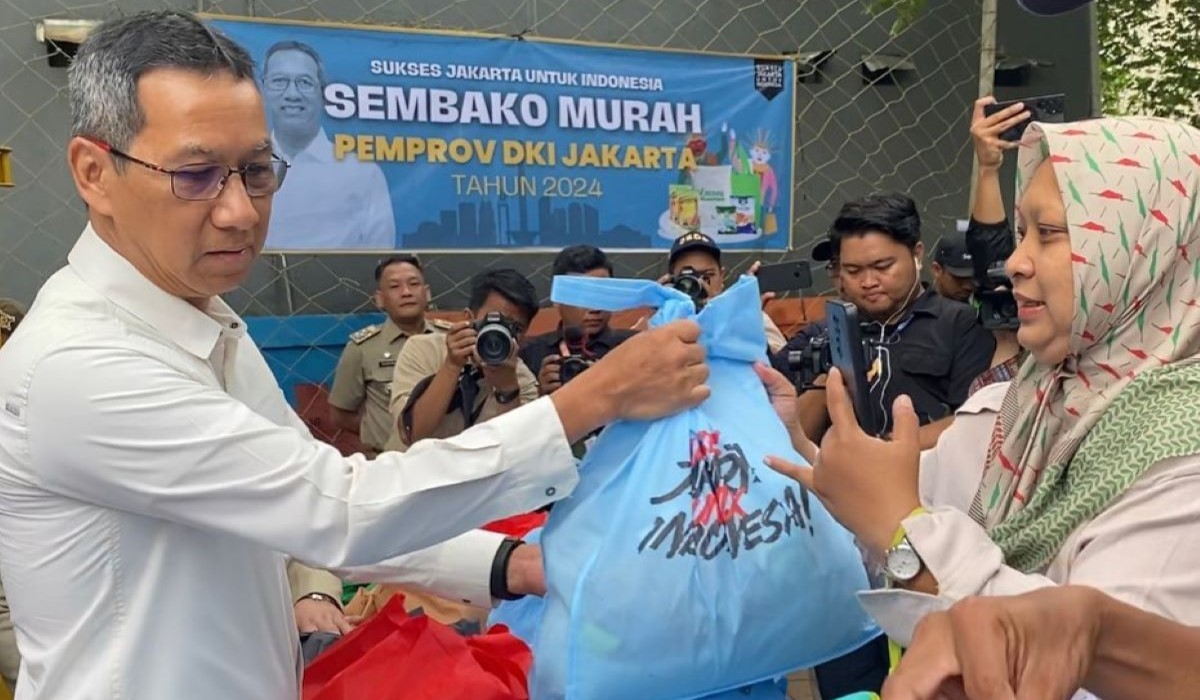 Wajah Penjabat (Pj) Gubernur Heru Budi Hartono dalam spanduk acara pasar sembako murah