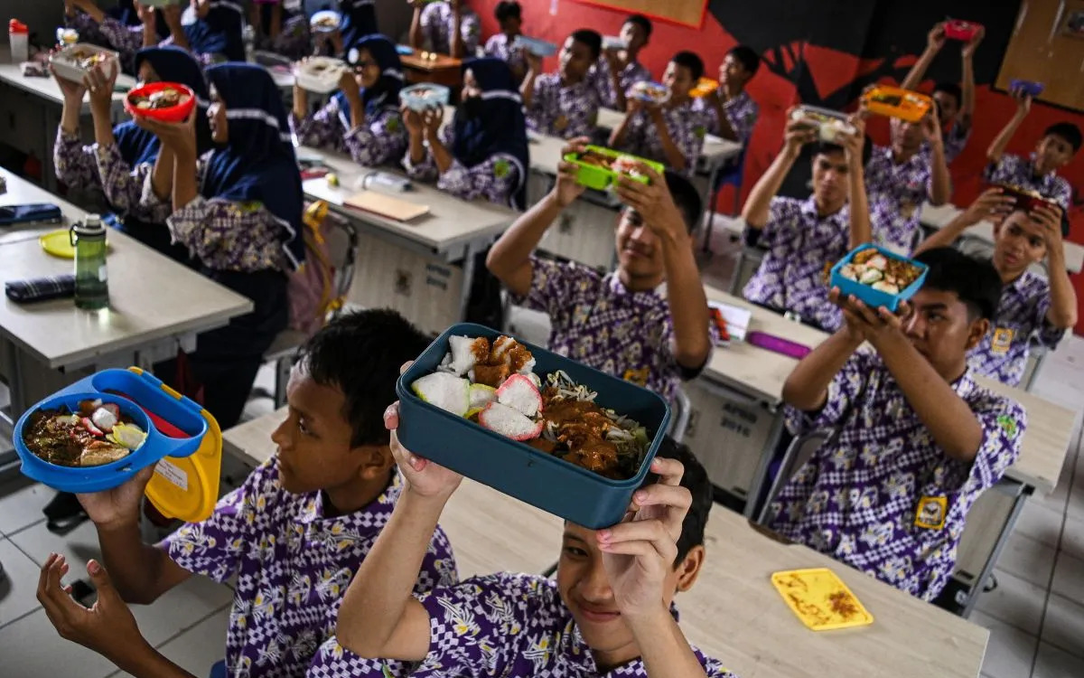 Sejumlah siswa menunjukkan makanan gratis saat simulasi program makan siang gratis di SMP Negeri 2 Curug, Kabupaten Tangerang, Banten, Kamis