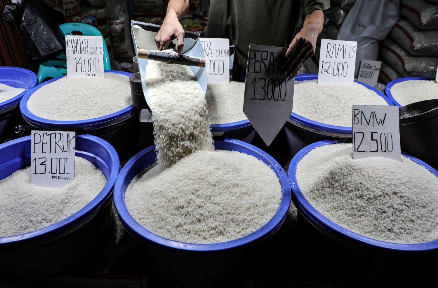 Pedagang menata beras di kios penjualan beras medium dan premium kawasan Petukangan Utara, Jakarta Selatan, Senin (26/2) malam.