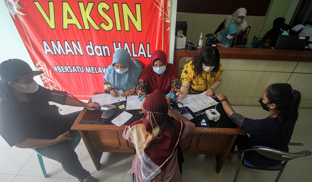 Petugas memeriksa kesehatan warga saat vaksinasi covid-19 di Puskesmas Buduran, Sidoarjo, Jawa Timur, Kamis (15/12/2022).