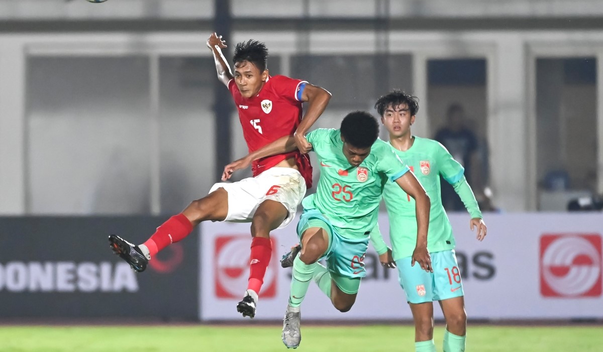 Pesepak bola Timnas U-20 Indonesia Dony Tri Pamungkas (kiri) berebut bola dengan pesepak bola Timnas U-20 China Su Yuliang 