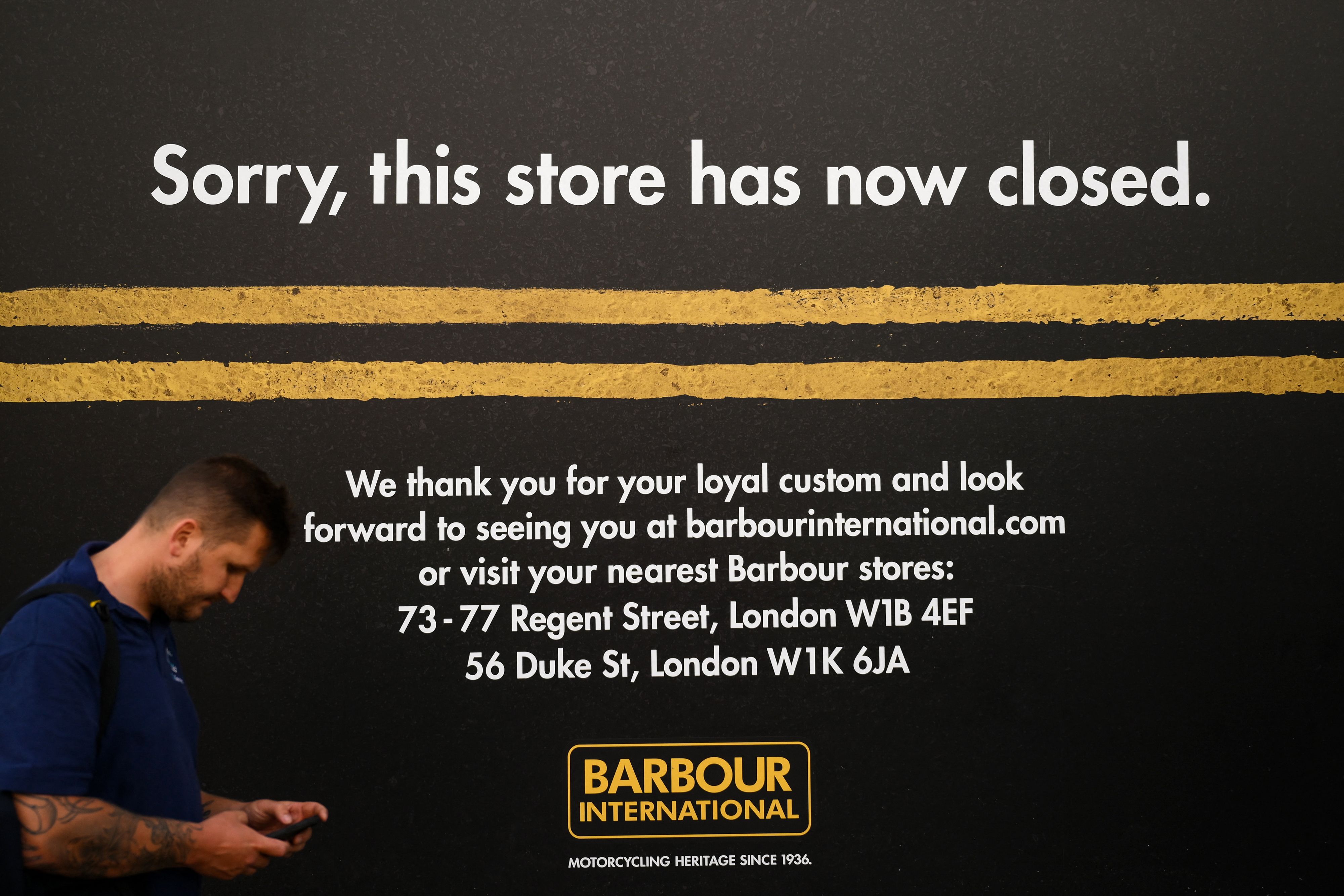 Seseorang berjalan melewati sebih toko yang tutup di Inggris.