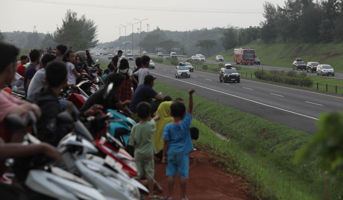 Warga menghabiskan waktu menunggu berbuka puasa (ngabuburit) Ramadan dengan menonton kendaraan yang lewat jalan tol 