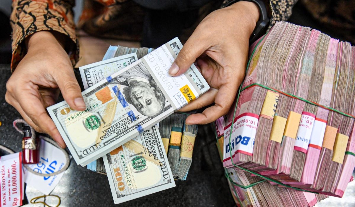 Ilustrasi: petugas menyusun uang pecahan dolar AS dan rupiah di gerai penukaran mata uang asing 