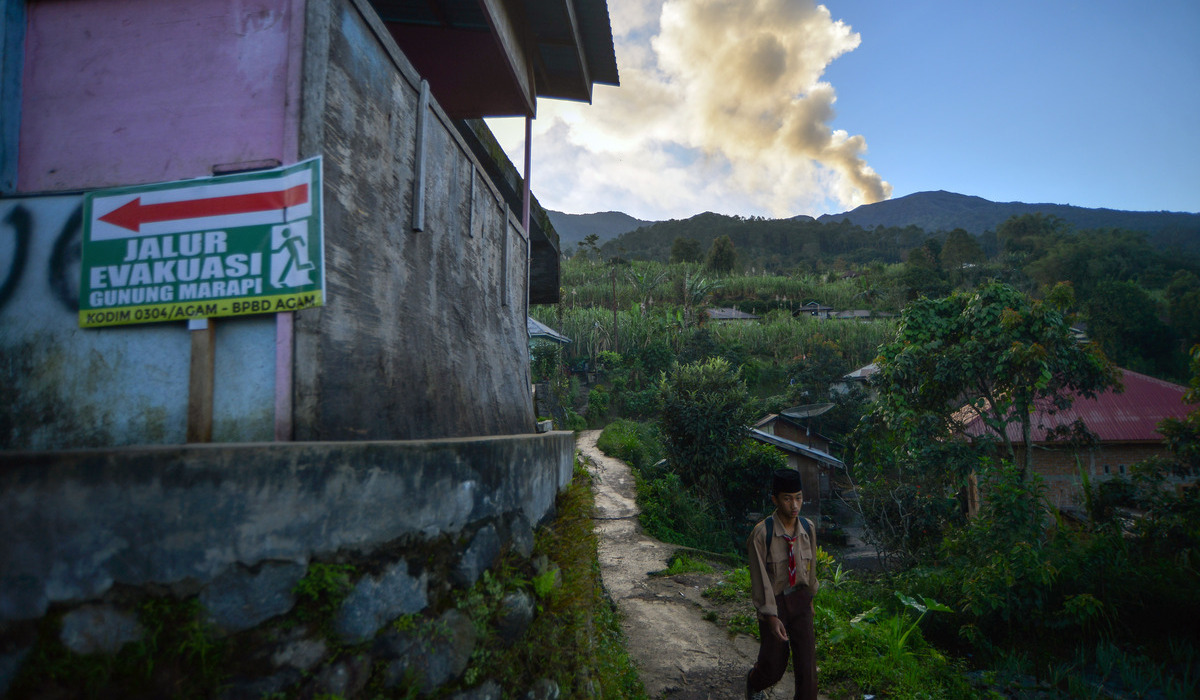 Pelajar berangkat ke sekolah saat Gunung Marapi mengeluarkan abu vulkanik, di Agam, Sumbar.
