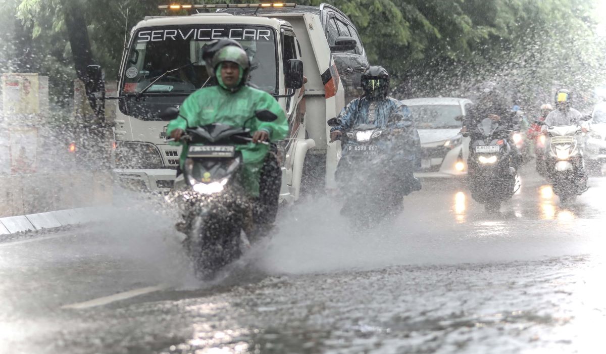 Pengendara sepeda motor melewati genangn air saat hujan deras di kawasan Alteri Pondok Indah Jakarta