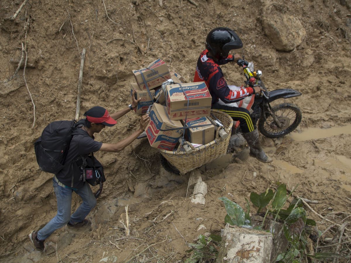 Warga membawa bantuan untuk korban banjir bandang dan longsor di Langgai, Gantiang Mudiak Utara Surantiah, Pesisir Selatan.