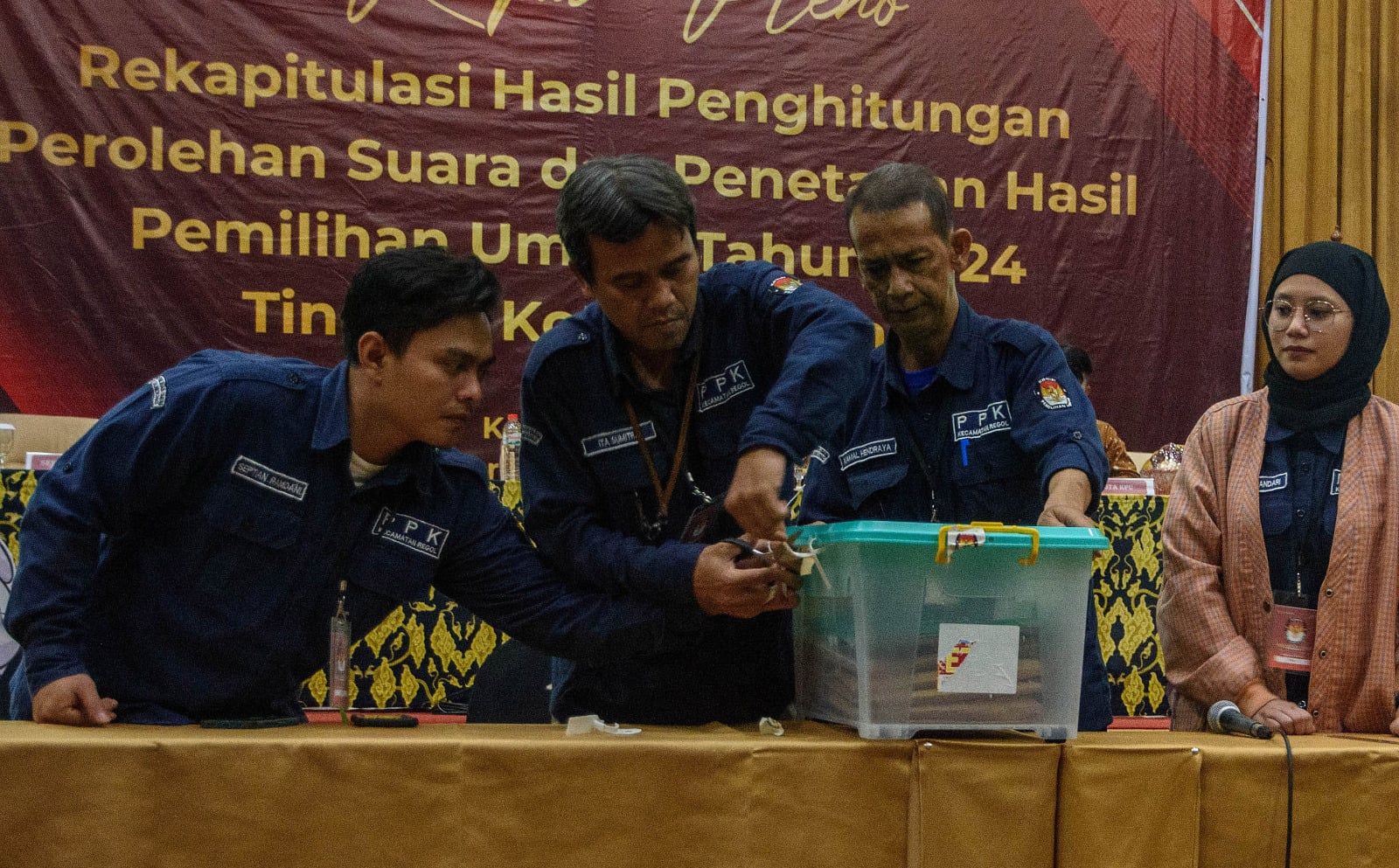 Anggota PPK membuka segel kontainer hasil penghitungan saat rapat pleno rekapitulasi perolehan suara hasil Pemilu 2024 Kota Bandung.