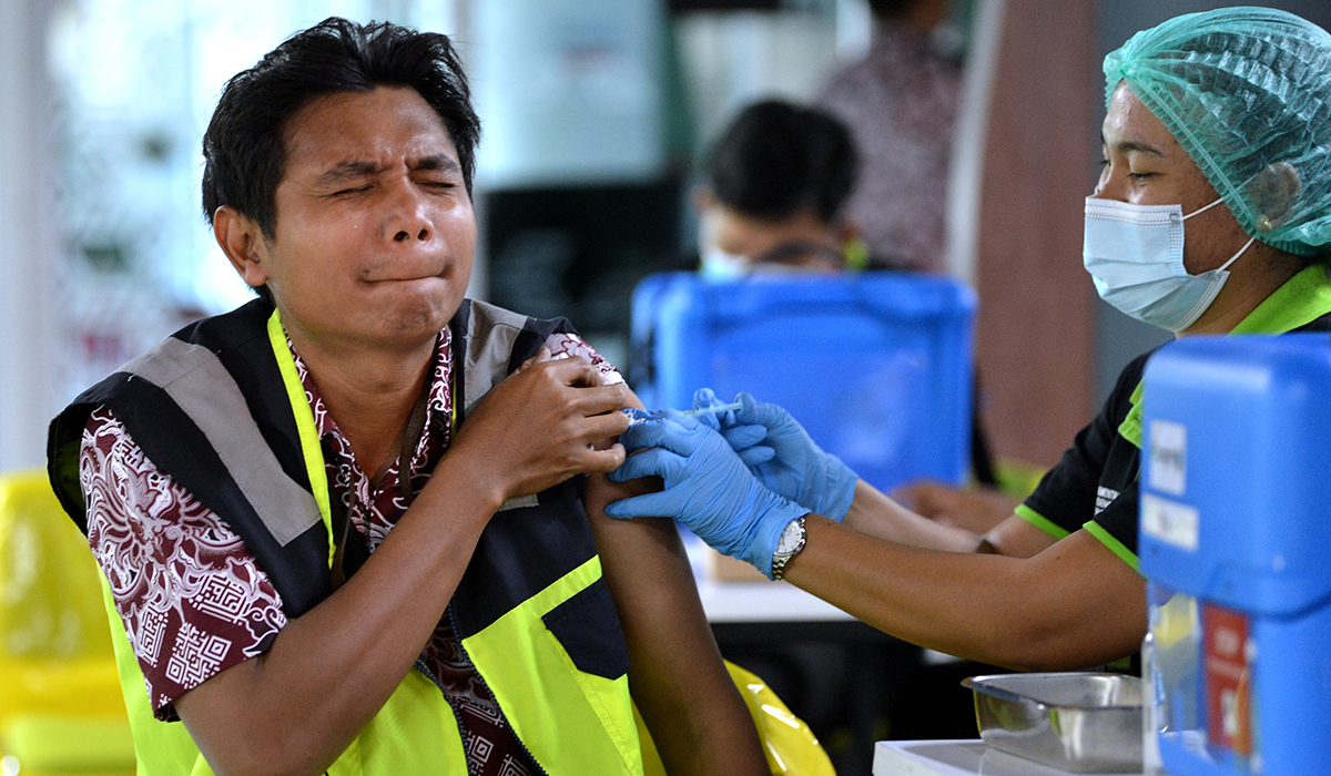 Vaksinator menyuntikkan vaksin covid-19 kepada petugas saat vaksinasi untuk petugas komunitas Bandara I Gusti Ngurah Rai di Badung, Bali.