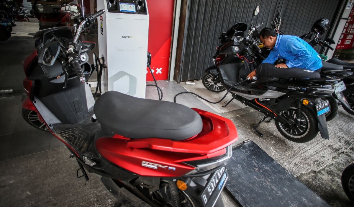Pengendara mengisi ulang baterai pada sepeda motor listrik di Jakarta 