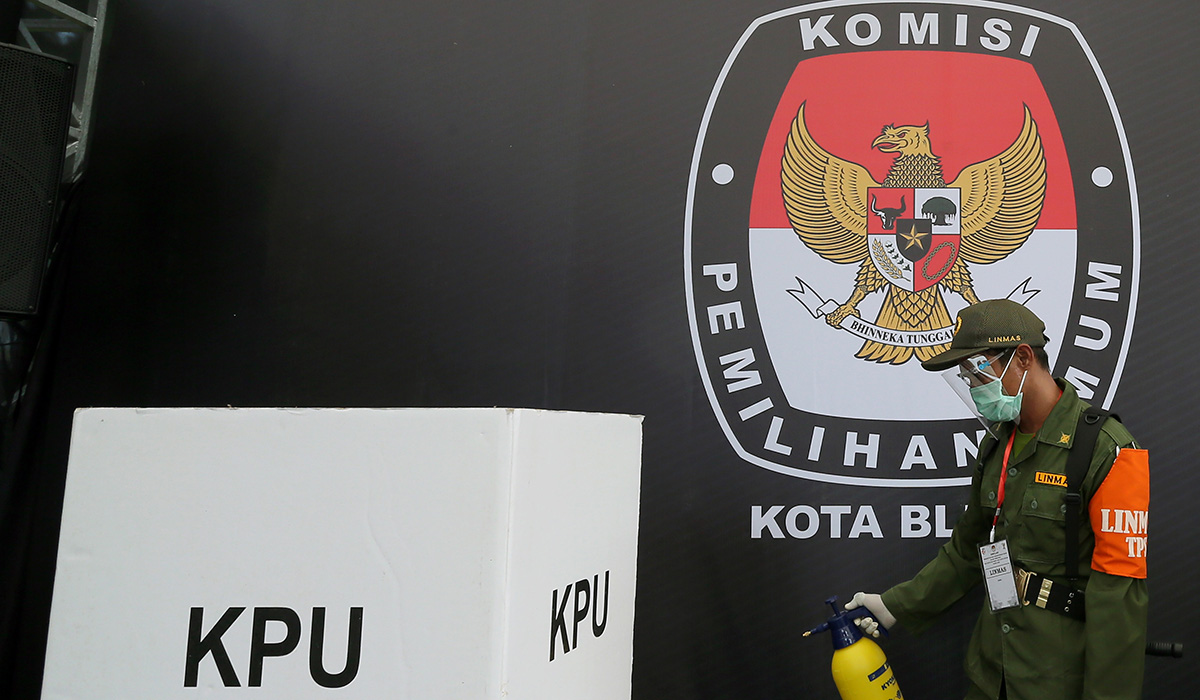 Petugas Linmas menyemprotkan cairan disinfektan ke area Tempat Pemungutan Suara (TPS) saat simulasi pemungutan suara Pilkada Serentak 2020.