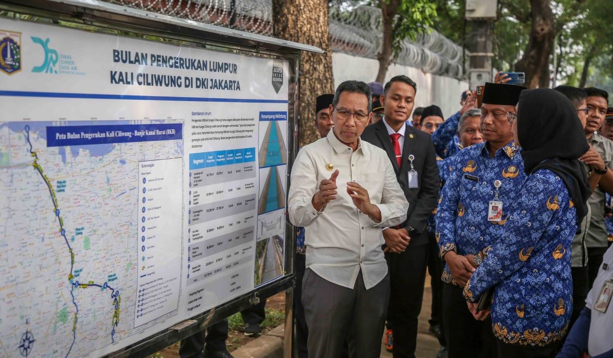 Penjabat (Pj) Gubernur DKI Jakarta Heru Budi Hartono (kiri) meninjau kegiatan pengerukan Sungai Ciliwung 