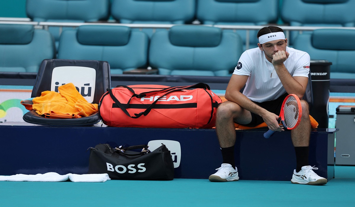 Petenis AS Taylor Fritz menunggu lapangan dibersihkan saat laga akan dilanjutkan usai jeda karena hujan.