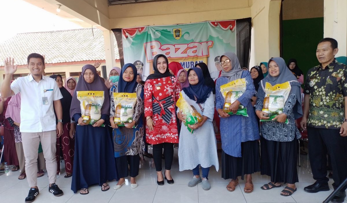 Bupati Sri Mulyani, Kepala Bulog Cabang Surakarta Andy Nugroho (baju putih), dan Camat Delanggu Joko Suparja foto bersama warga.