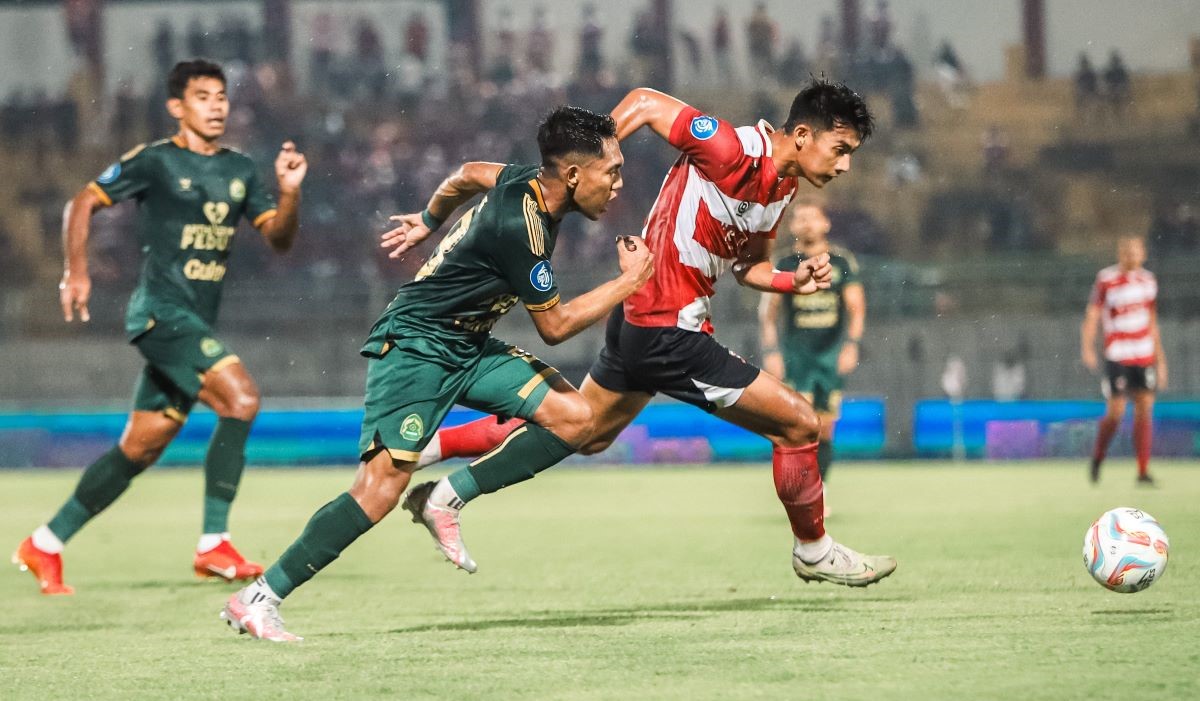 Pesepak bola Madura United Malik Risaldi (kanan) melewati hadangan pesepak bola Persikabo 1973 