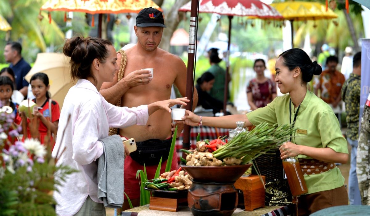 Wisatawan mancanegara mencoba meminum jamu tradisional saat kegiatan Eco Market di kawasan pariwisata The Nusa Dua, Badung, Bali