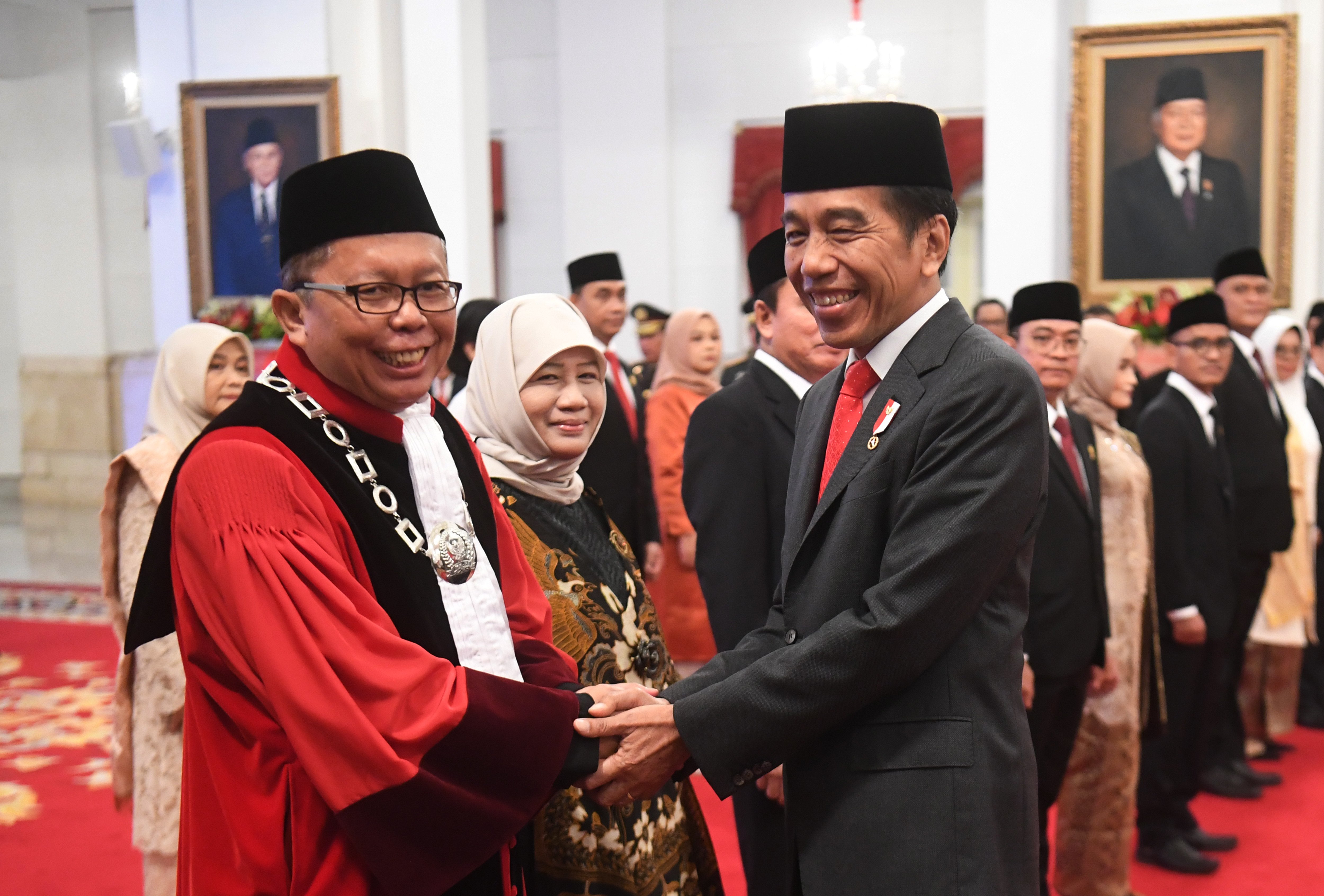 Presiden Joko Widodo (kanan) berjabat tangan dengan Hakim Konstitusi Arsul Sani (kiri)