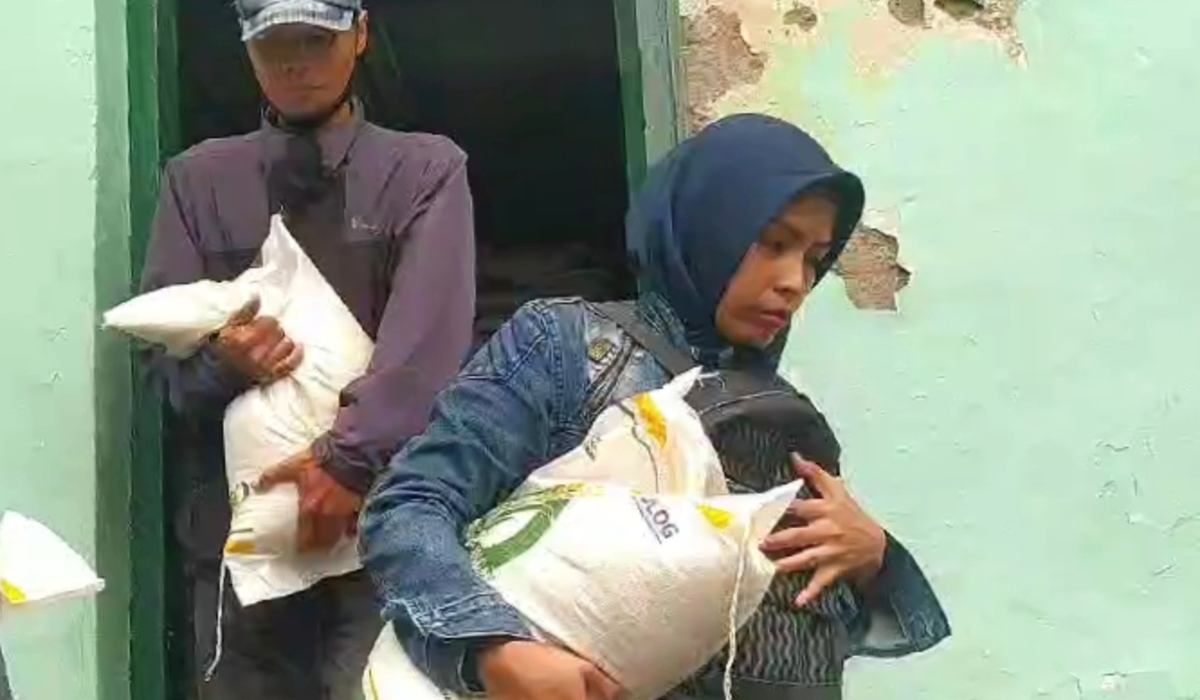 Warga menerima pembagian bantuan cadangan pangan (CPP) beras.