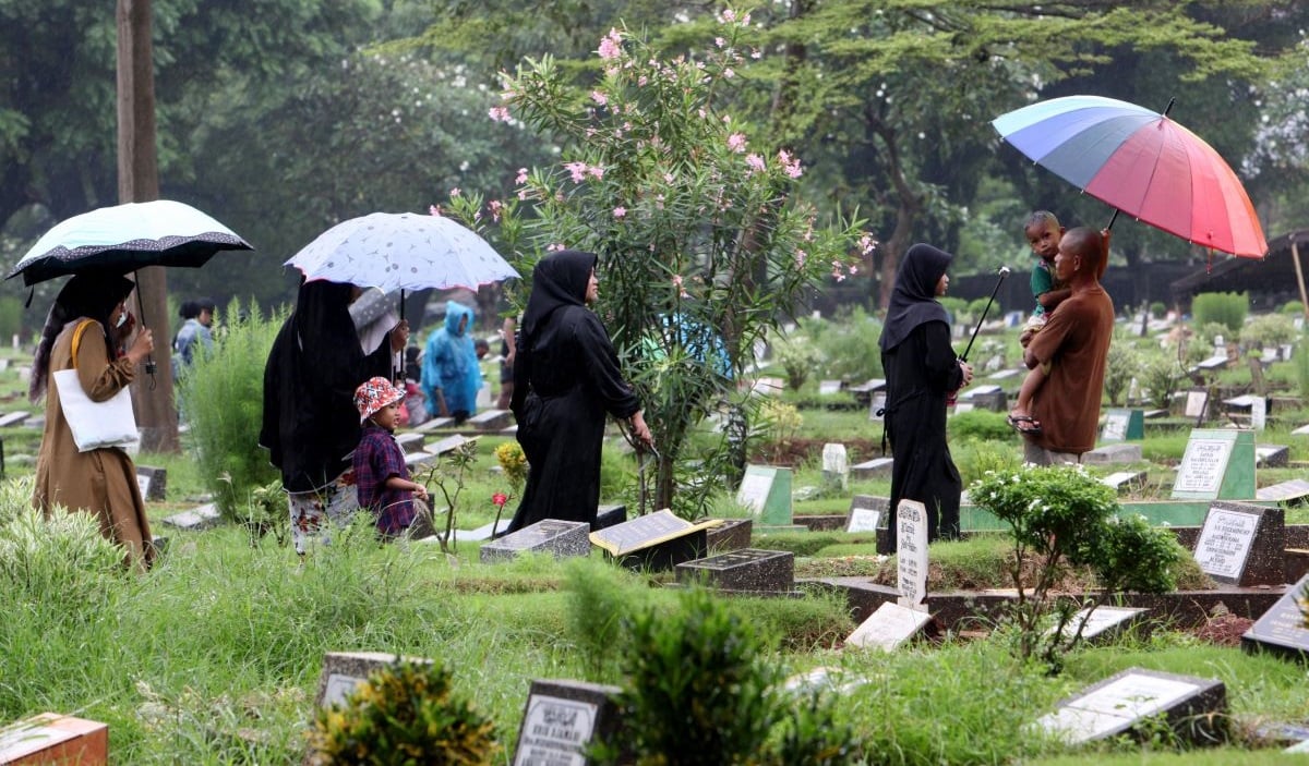 Masyarakat mendatangi makam untuk mengirimkan doa kepada keluarga yang telah wafat di Taman Pemakaman Umum (TPU) Karet Bivak, Jakarta.