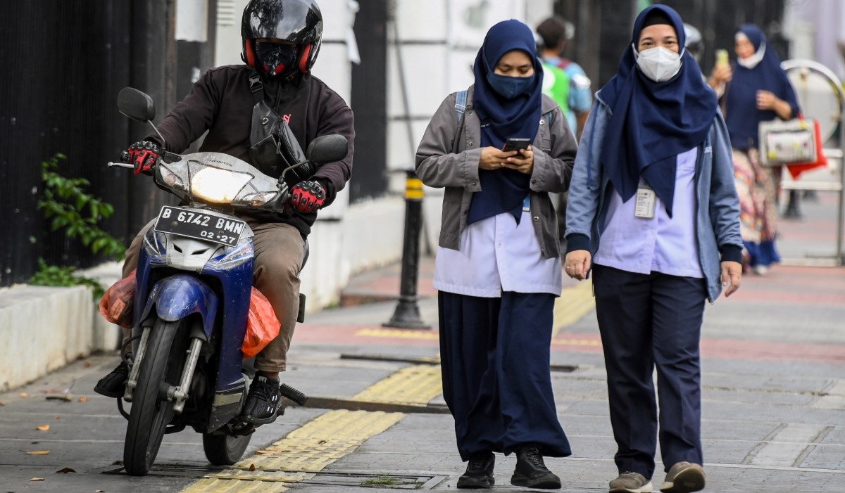 Ilustrasi: pengendara sepeda motor menghindari pejalan kaki saat melintasi jalur pedestrian di Jalan Medan Merdeka Timur 